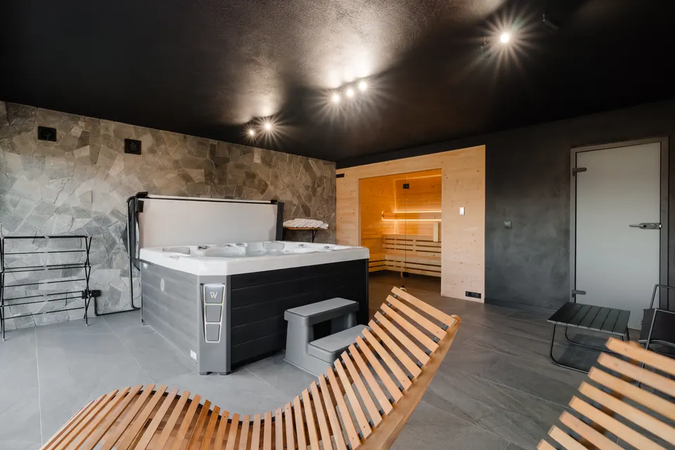 Jacuzzi, sauna i drewniane leżaki w strefie SPA